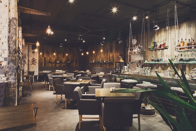 Interiør i en koselig restaurant. Moderne design i loftstil, moderne spisested og bardisk, kopieringsplass