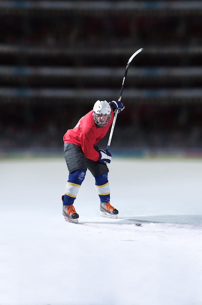 Ishockeyspiller i aksjon som sparker med kølle