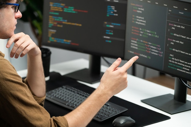 IT developer working online software development coding on pc screens Gusher