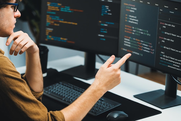 IT developer working online software development coding on pc screens Gusher