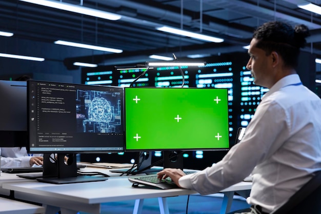 IT expert inspecting neural network data center with chroma key PC