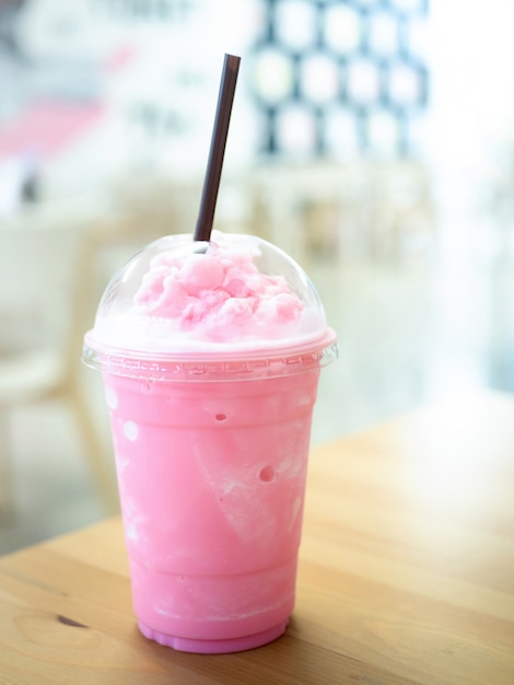 Kald melk smoothie i en plastkopp på et trebord