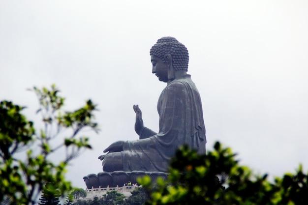 Lav vinkelvisning av Tian Tan Buddha mot himmelen