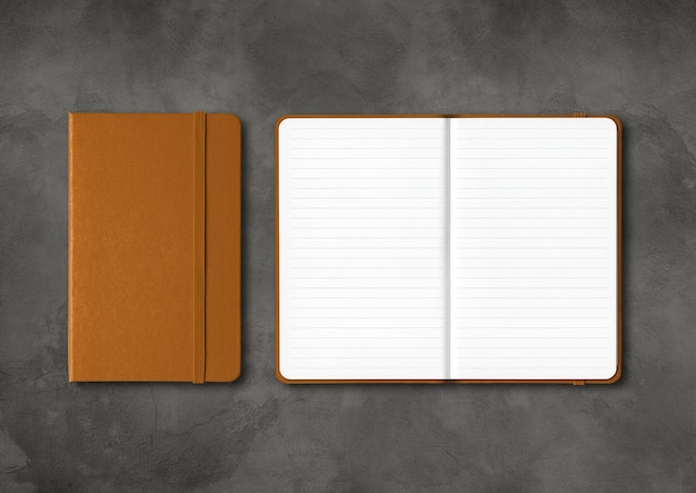 Leather closed and open lined notebooks  isolated on dark concrete background