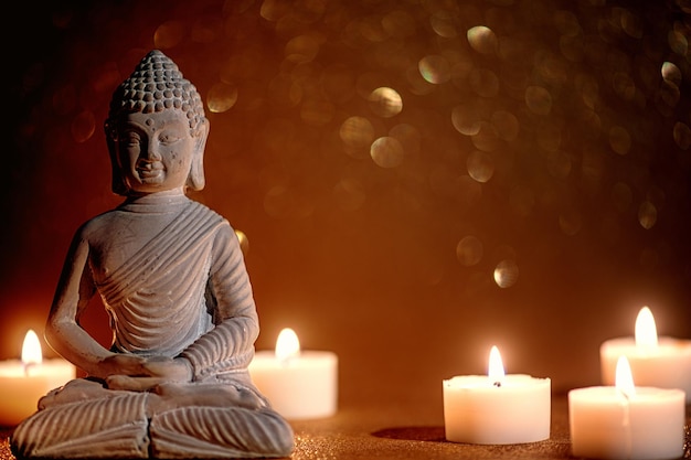 Little buddha statue surrounded by tea candles