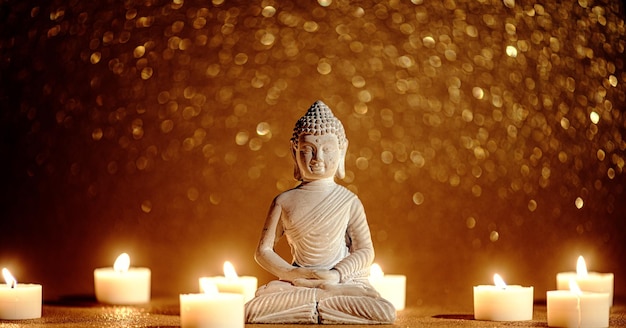 Little buddha statue surrounded by tea candles