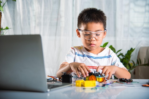 Little child trying assemble build wheel to car toy