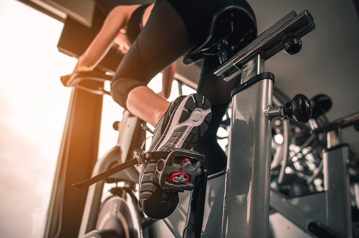 Foto low angle view of woman exercising on bike in gym