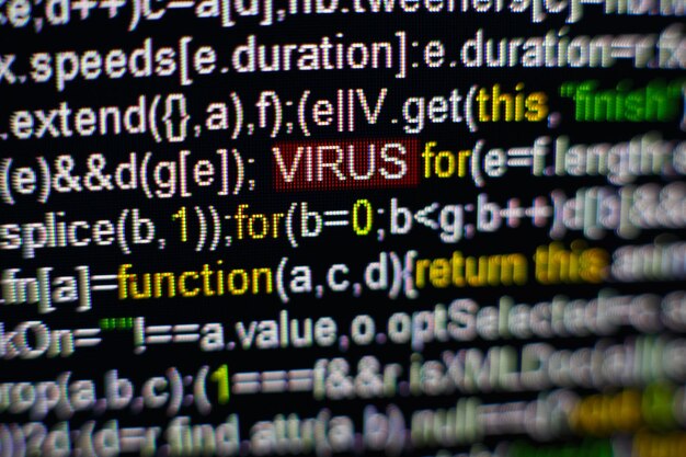 Macro photo of computer screen with program source code and highlighted VIRUS inscription in the middle Script on the screen with virus in it Cyber security concept Technology background