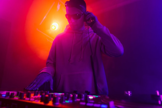 Male dj playing music in the night club