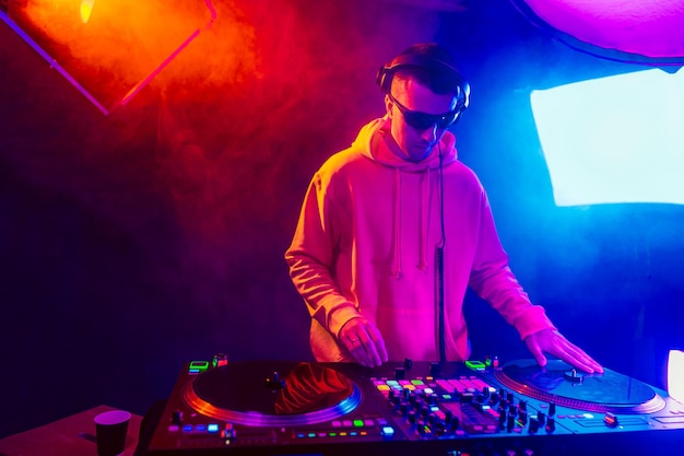 Male dj playing music in the night club