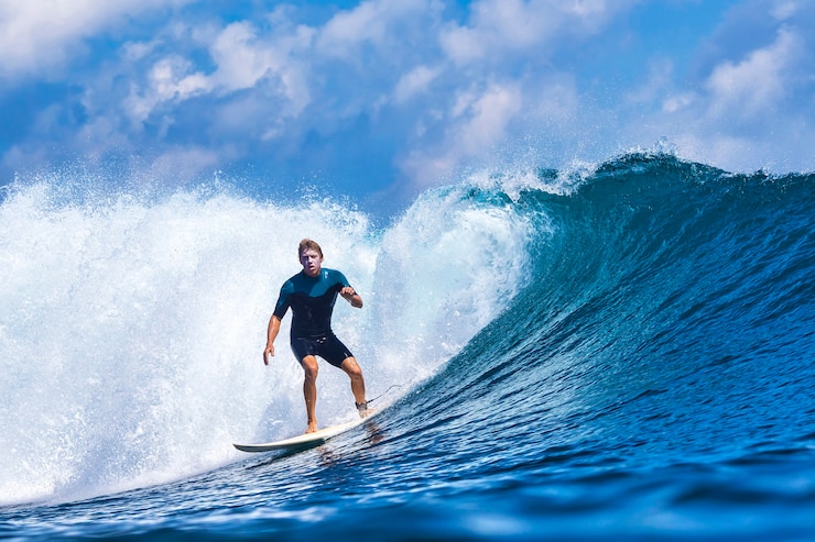 Foto male surfer on a blue wave at sunny day