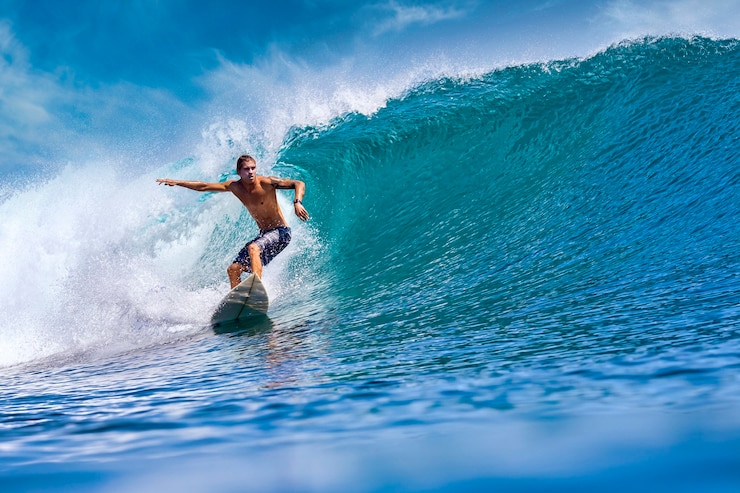 Foto male surfer on a blue wave at sunny day