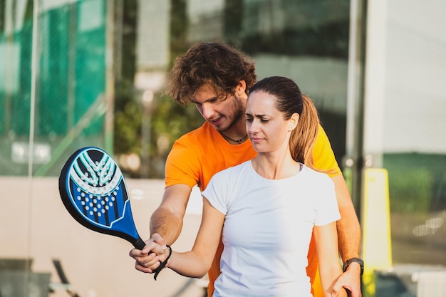 Man and woman holding tennis racket