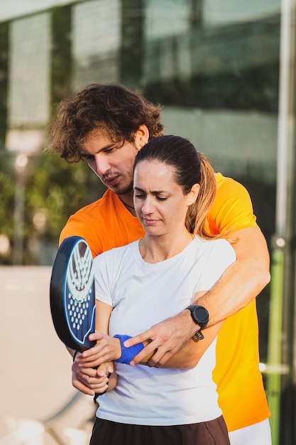 Man and woman holding tennis racket