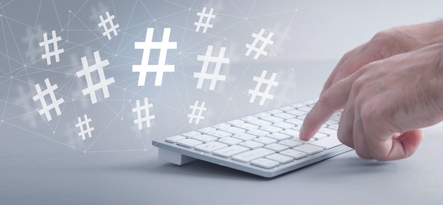 Mannlige hender som skriver på datamaskinens tastatur. Hashtag. Sosiale medier