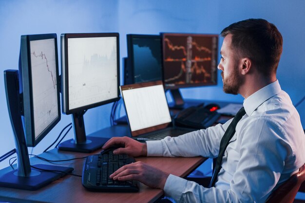 many of the monitors stock trader working in the office with exchange technology