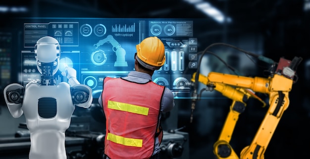 Mekanisk industrirobot og menneskelig arbeider som jobber sammen i fremtidens fabrikk