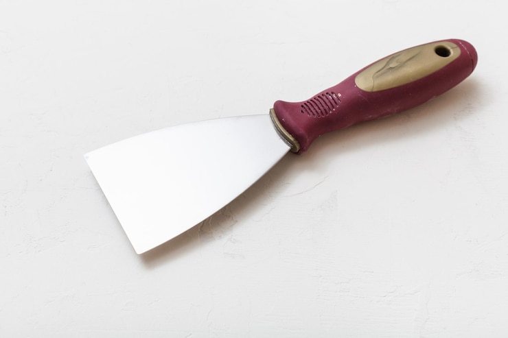 Foto metal spatula with plastic handle on floor