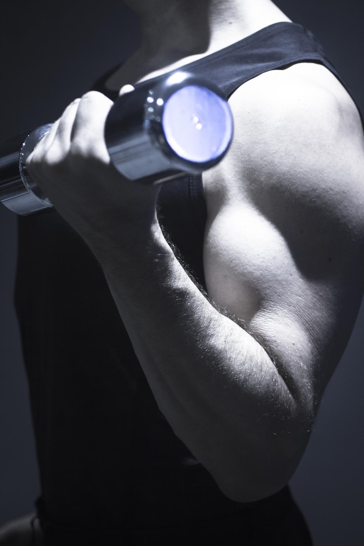 Foto midsection of man exercising with dumbbell in gym