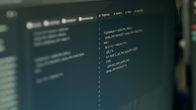 Monitor display of software developer typing database functions script to code system server in software company office. Writing source code and big data programming language. Close up.