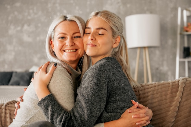 Mor som klemmer en tenåringsdatter hjemme familieforhold