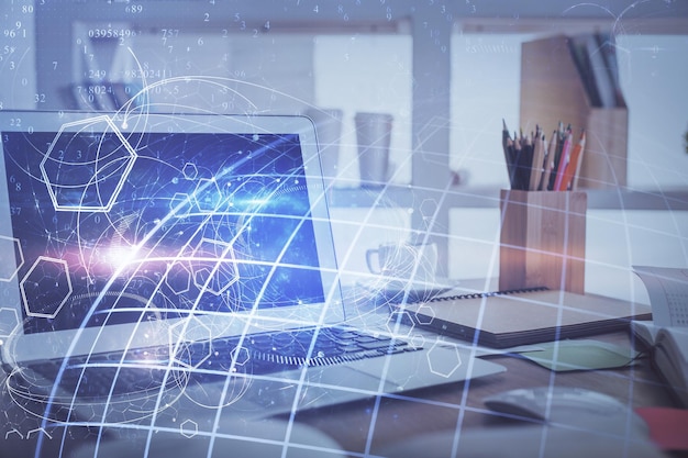 multi exposure of table with computer and world map hologram international data network concept