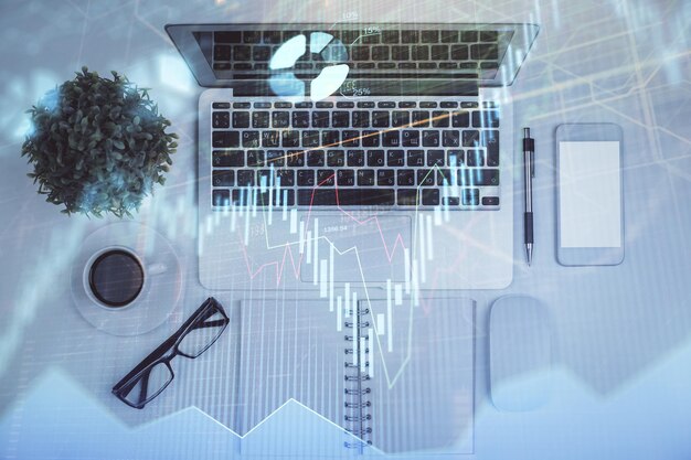 Multieksponering av valutadiagramtegning over bordbakgrunn med datamaskin Konsept for finansielle undersøkelser og analyser Toppvisning