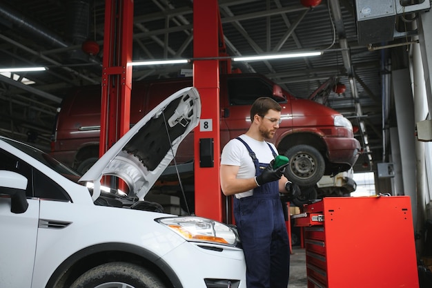 Muscular car service worker repairing vehicle