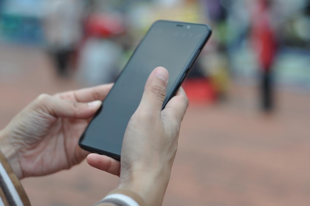 Nærbilde av hånd som holder mobiltelefon