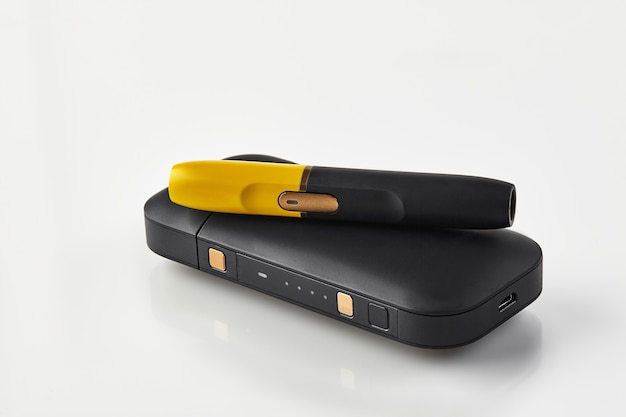New generation black and yellow electronic cigarette is on battery isolated on white hitech heating ...
