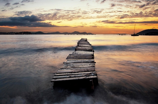 Old pier on sea at sunset