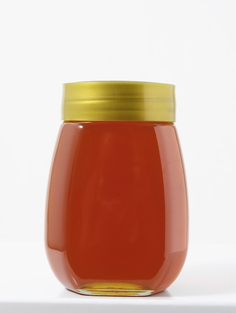 one full honey jar on a white background