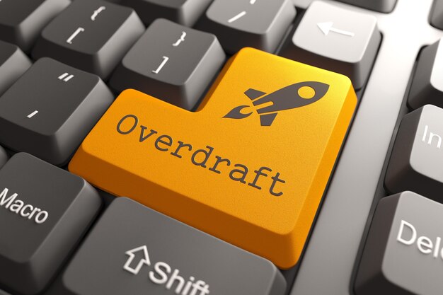 Oransje knapp med Overdraft på svart datamaskintastatur. Bankkonsept.