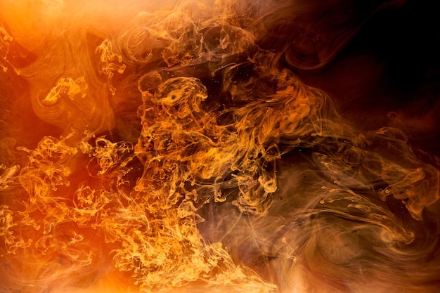 Oransje røyk på svart blekkbakgrunn, fargerik tåke, abstrakt virvlende hav, akrylmaling pigment under vann