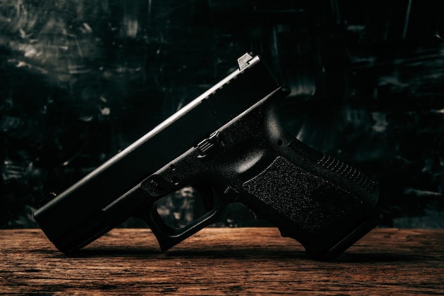 Portrait of a black 9mm pistol on an old wooden floor