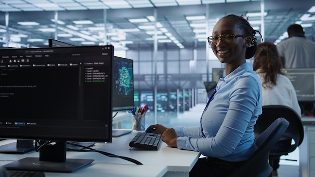 Portrait of happy computer scientist programming in AI data center