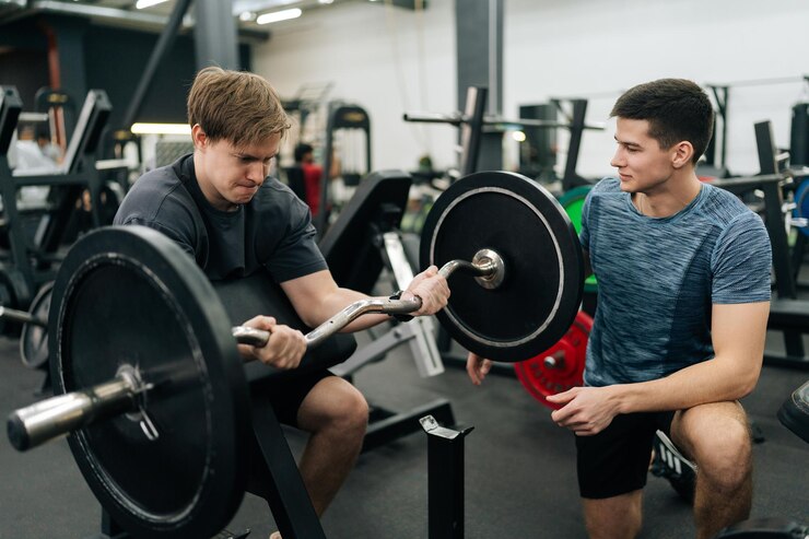 Foto portrait of motivated beginner sportsman hard time working out in gym with personal trainer at gym