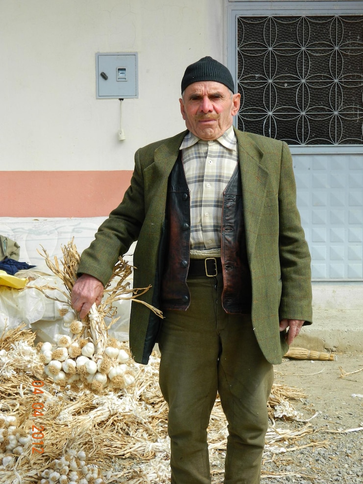 Foto portrait of senior man holding garlic