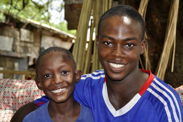 Portrait of smiling siblings sitting outdoors