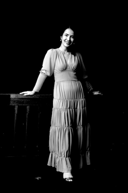 portrait of woman standing against black background