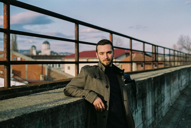 portrait of young man standing against retaining wall