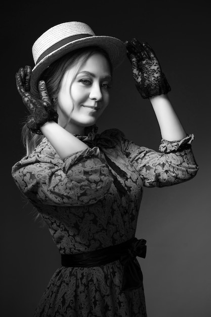 portrait of young woman standing against black background