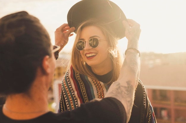 rear view of man putting hat on happy girlfriend head