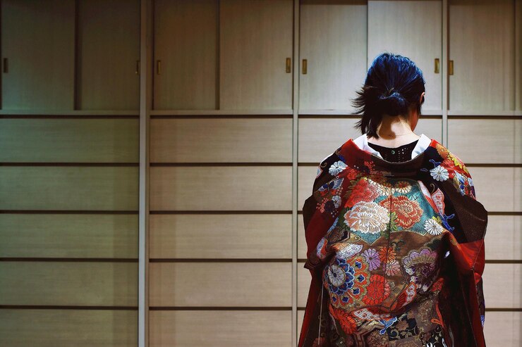 Foto rear view of mid adult woman standing against wall