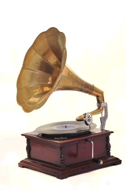 retro old gramophone with horn speaker  for playing music over plates  isolated on white in studio