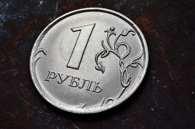 russian coin with a face value of 1 ruble lies on a dark metal surface closeup