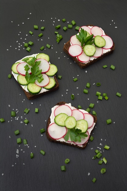 Sandwiches with radish, cucumber on a rye bread.