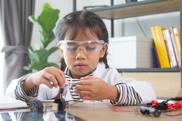 school student making robotic cars girl at robotics school makes robot managed from the constructor child learns robot constructing