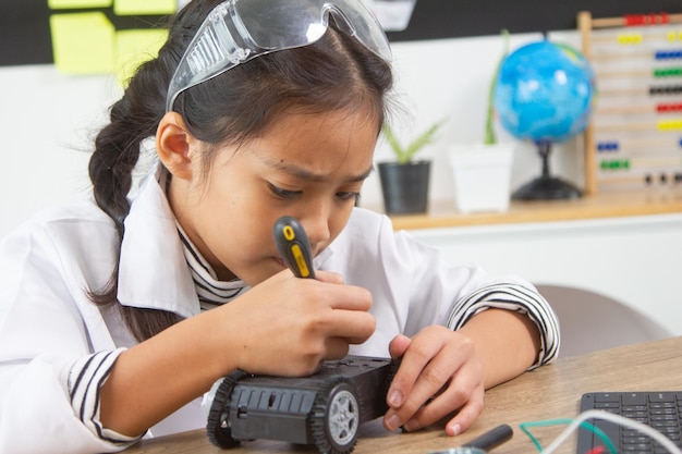 school student making robotic cars girl at robotics school makes robot managed from the constructor child learns robot constructing